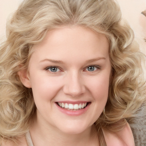 Joyful white young-adult female with long  blond hair and blue eyes