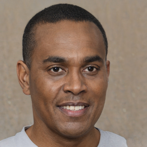 Joyful black young-adult male with short  black hair and brown eyes