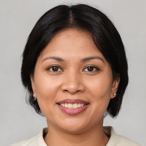 Joyful latino adult female with medium  brown hair and brown eyes