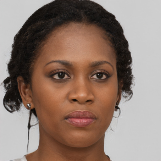 Joyful black young-adult female with medium  brown hair and brown eyes