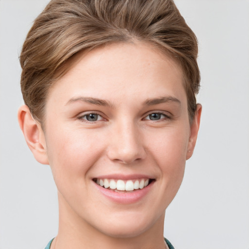 Joyful white young-adult female with short  brown hair and grey eyes