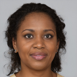 Joyful black adult female with medium  brown hair and brown eyes