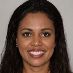 Joyful black young-adult female with long  brown hair and brown eyes