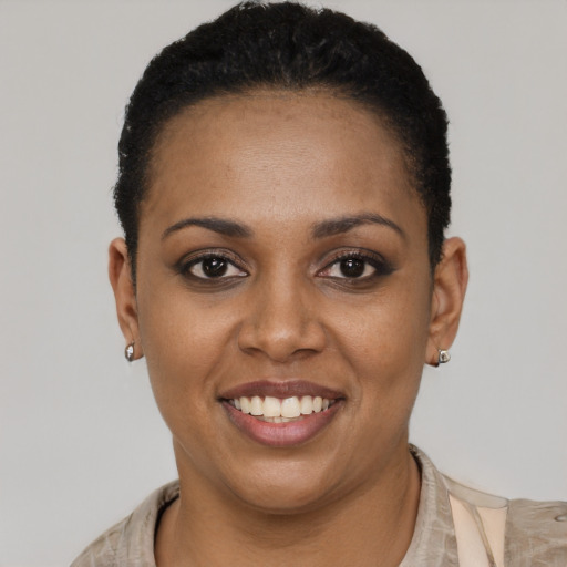 Joyful black young-adult female with short  black hair and brown eyes