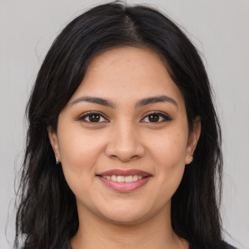 Joyful latino young-adult female with long  brown hair and brown eyes