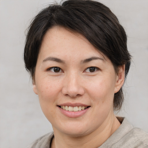 Joyful asian adult female with medium  brown hair and brown eyes