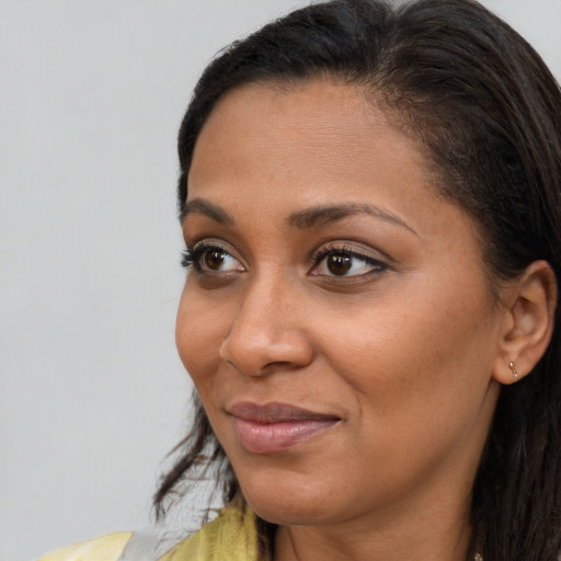 Joyful latino adult female with long  brown hair and brown eyes