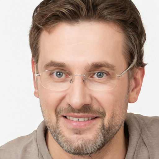 Joyful white adult male with short  brown hair and blue eyes