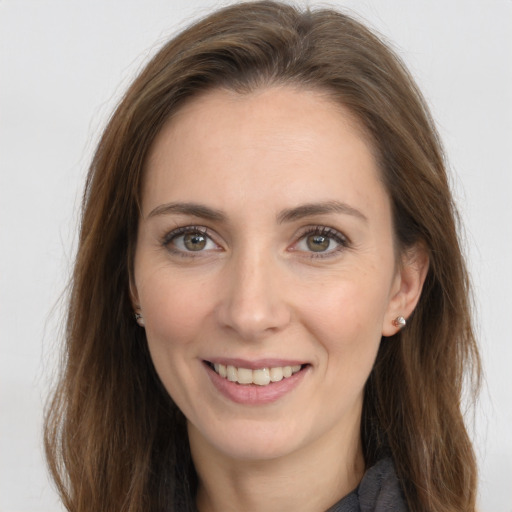 Joyful white young-adult female with long  brown hair and green eyes