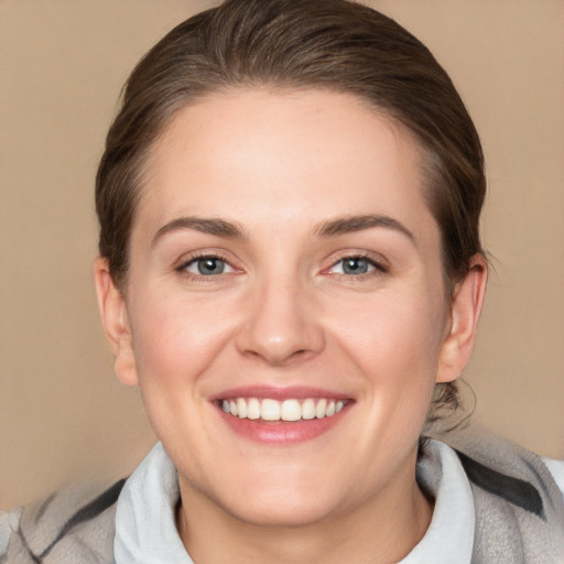 Joyful white young-adult female with medium  brown hair and grey eyes