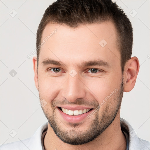 Joyful white young-adult male with short  brown hair and brown eyes