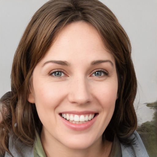 Joyful white young-adult female with medium  brown hair and grey eyes