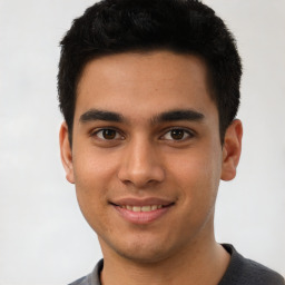 Joyful latino young-adult male with short  brown hair and brown eyes