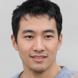 Joyful asian young-adult male with short  black hair and brown eyes