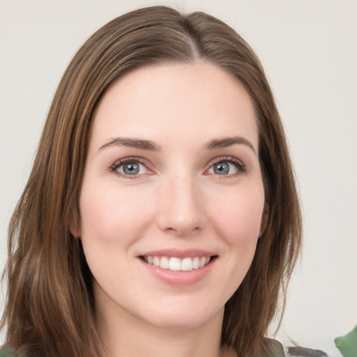 Joyful white young-adult female with long  brown hair and green eyes