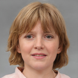 Joyful white young-adult female with medium  brown hair and blue eyes