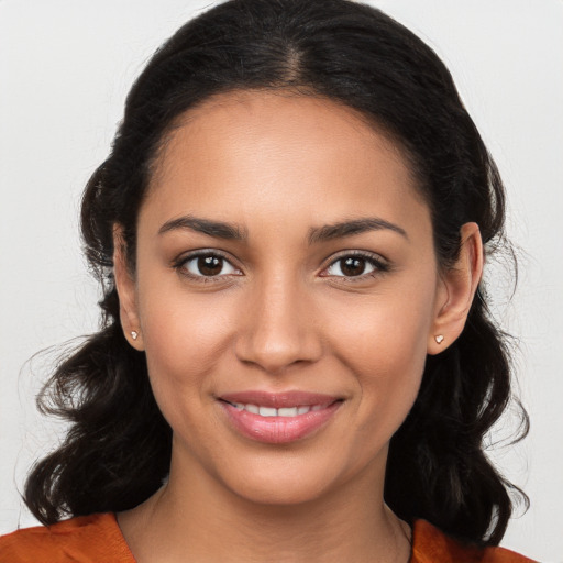 Joyful latino young-adult female with long  brown hair and brown eyes