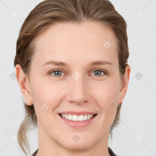 Joyful white young-adult female with medium  brown hair and grey eyes