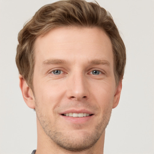 Joyful white young-adult male with short  brown hair and grey eyes