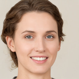 Joyful white young-adult female with medium  brown hair and green eyes