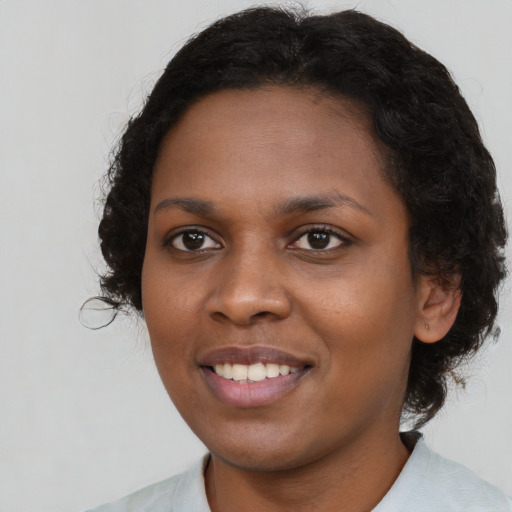 Joyful black young-adult female with medium  brown hair and brown eyes