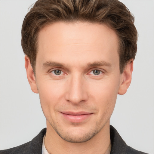 Joyful white young-adult male with short  brown hair and grey eyes