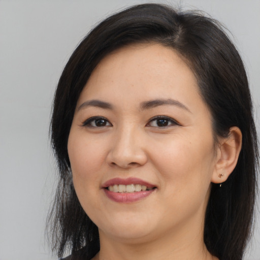 Joyful asian young-adult female with long  brown hair and brown eyes