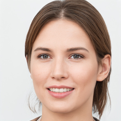 Joyful white young-adult female with medium  brown hair and grey eyes