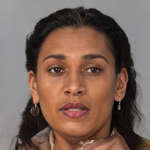 Joyful black adult female with medium  brown hair and brown eyes