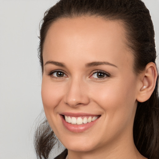 Joyful white young-adult female with long  brown hair and brown eyes