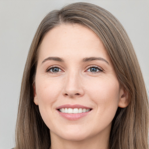 Joyful white young-adult female with long  brown hair and grey eyes