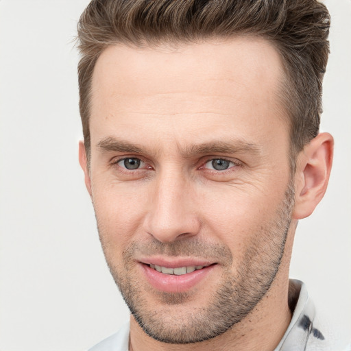 Joyful white adult male with short  brown hair and brown eyes