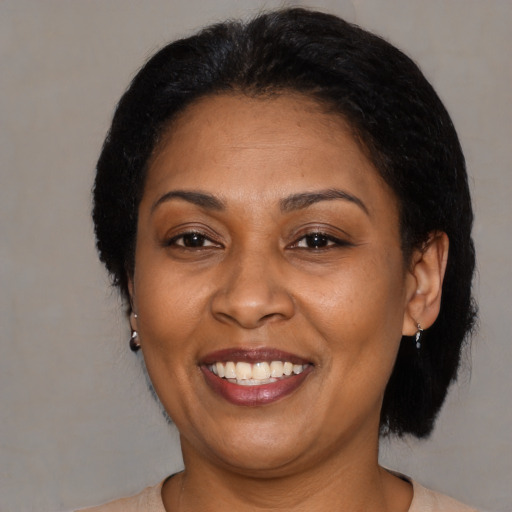 Joyful latino adult female with medium  brown hair and brown eyes