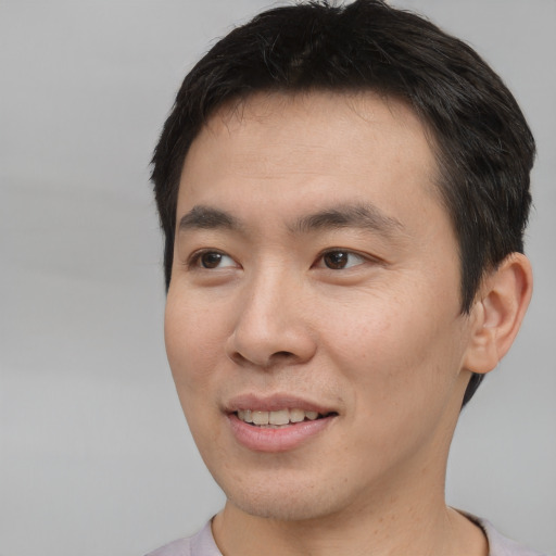Joyful asian young-adult male with short  brown hair and brown eyes