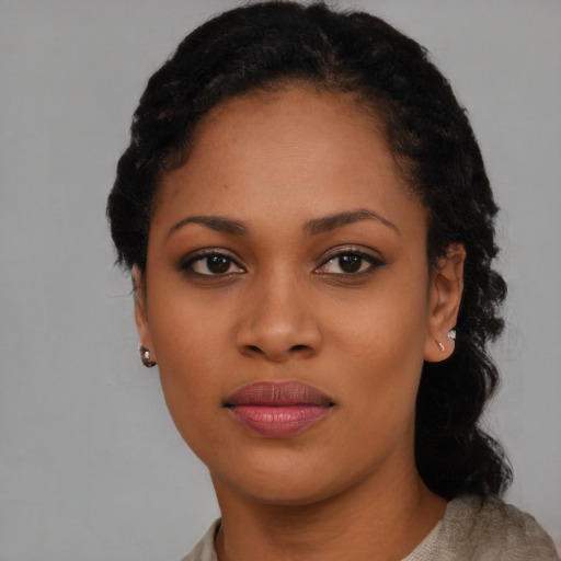 Joyful black young-adult female with short  black hair and brown eyes