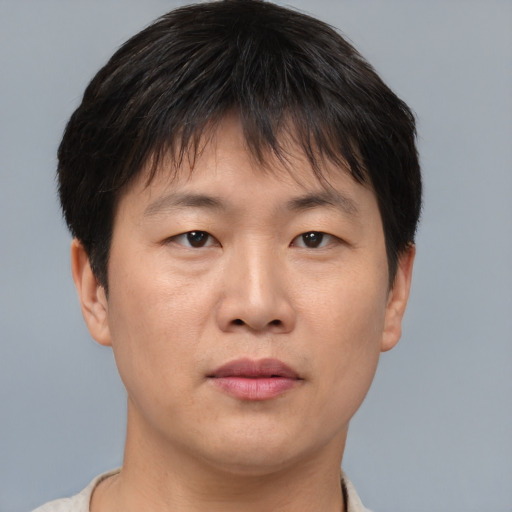 Joyful asian adult male with short  brown hair and brown eyes