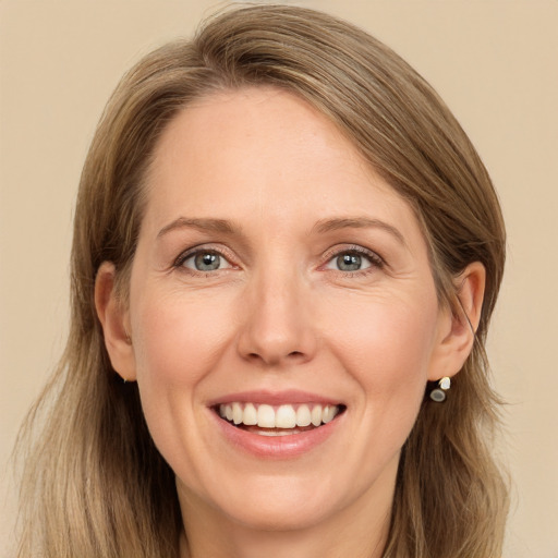 Joyful white adult female with long  brown hair and grey eyes