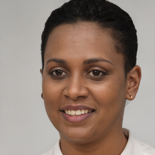 Joyful black young-adult female with short  black hair and brown eyes