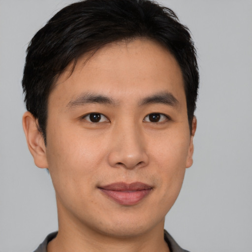 Joyful asian young-adult male with short  brown hair and brown eyes