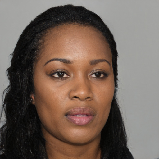 Joyful black young-adult female with long  black hair and brown eyes