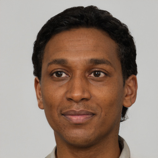 Joyful black adult male with short  black hair and brown eyes