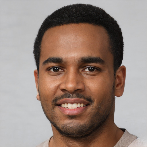 Joyful black young-adult male with short  black hair and brown eyes