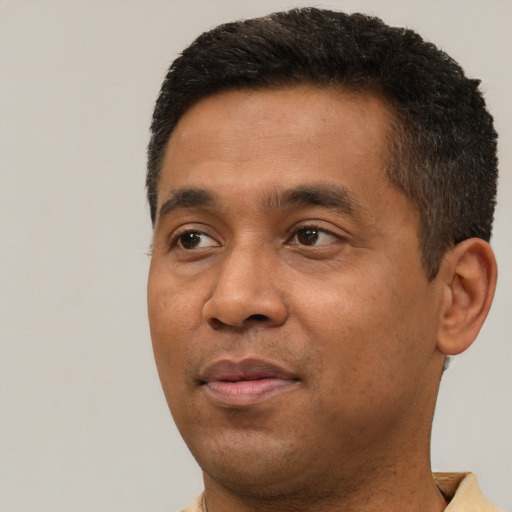 Joyful latino adult male with short  brown hair and brown eyes