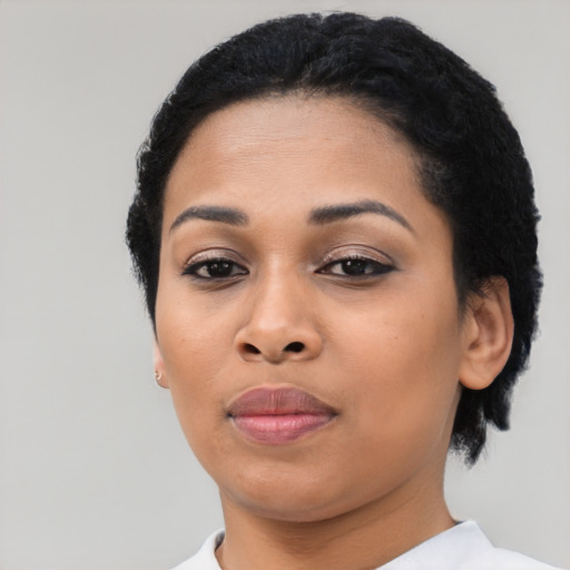 Joyful black young-adult female with short  black hair and brown eyes