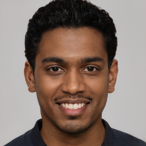 Joyful black young-adult male with short  black hair and brown eyes