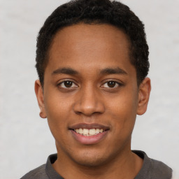 Joyful black young-adult male with short  brown hair and brown eyes