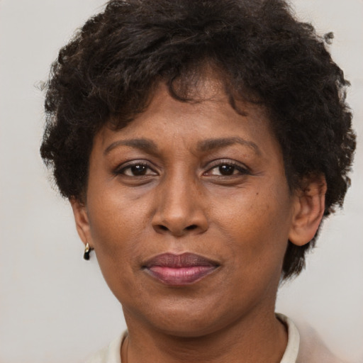 Joyful black adult female with short  brown hair and brown eyes