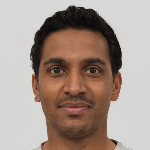 Joyful black young-adult male with short  black hair and brown eyes