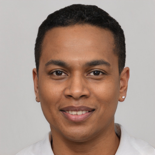 Joyful black young-adult male with short  black hair and brown eyes