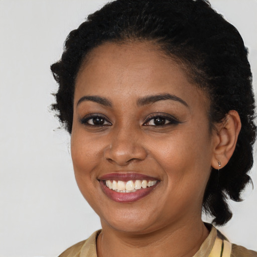 Joyful black young-adult female with long  brown hair and brown eyes